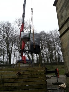 crane lifting our new boiler over the hall